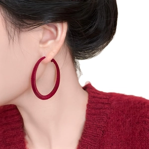 Vintage red flocked hoop earrings for women shown on a model with a cozy knit sweater