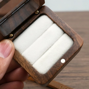Macro shot of walnut jewelry box showing velvet ring slots and natural wood grain