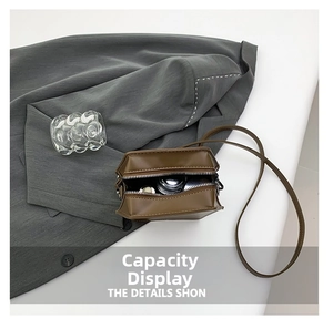 Interior capacity display of a brown faux leather crossbody bag with items