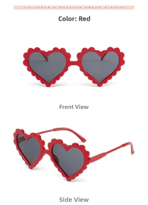 Detail view of red heart-shaped kids sunglasses with scalloped wavy frames and grey lenses