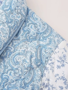 Detailed view of blue paisley quilted fabric and floral pattern with stitching