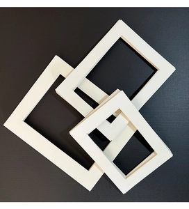 Macro detail of white picture frame mats with 45-degree bevel cut edges on black background