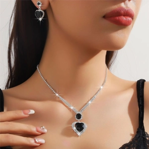 Close-up of sparkling heart-shaped black gemstone necklace and earrings set on model