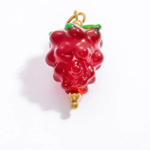 Détail d'un pendentif baie rouge avec feuilles vertes et crochet en métal doré