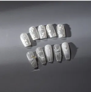 Detail of elegant white 3D floral nail stickers with pearl accents and ribbon design