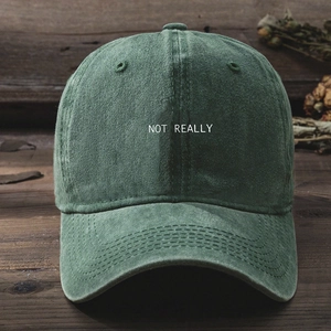 Detail of Y2K washed green baseball cap with NOT REALLY embroidery on a wooden table