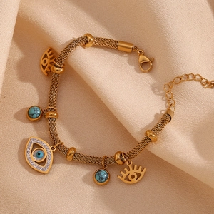 Detail of 18K gold-plated evil eye bracelet with turquoise beads on satin fabric