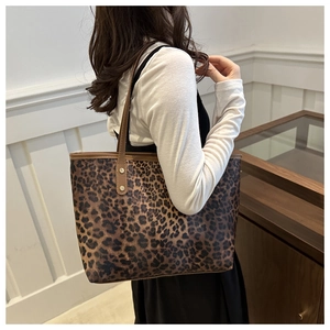 Detail view of large leopard print tote bag featuring metallic rivet reinforced straps
