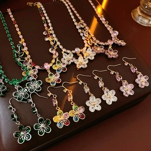 Detail view of zircon flower pendant necklace and earrings set on premium leather base