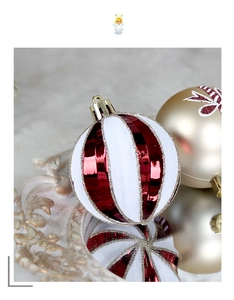 Close-up of red and white striped Christmas ornaments with gold glitter on reflective surface