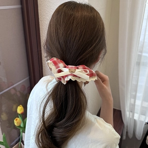 Red plaid scrunchie with lace edges and bear bow shown on a ponytail back view