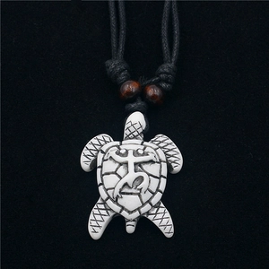 Carved white turtle pendant necklace with tribal totem on black cord with wood beads