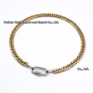 Macro shot of two-tone Cuban link chain with silver carabiner clasp and gold finish