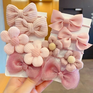 Detailed view of pink floral and bow hair ties set for kids on display cards