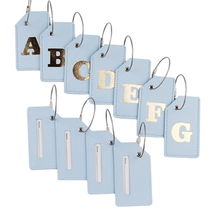 Detail of 11 light blue PU leather luggage tags with gold A-G letters and steel loops