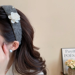 Detail of grey knitted headband with 3D white velvet flowers and pearl center accents