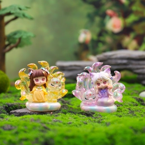 Macro shot of two Nine-Tailed Fox Fairy resin figurines on cloud bases in a garden
