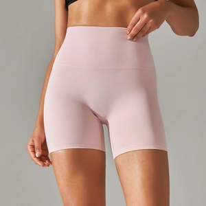 Detail of high-waisted pale pink yoga shorts showing peach-lift design and soft fabric