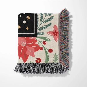 Detailed view of woven Christmas blanket with poinsettia patterns and fringe edges