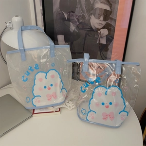 Détail d'un lot de deux sacs cabas en PVC transparent avec poignées bleues et lapin