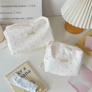 Detail der weißen gestreiften Kosmetiktaschen mit rosa Herzen und Markenetikett