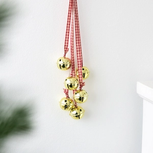 Hanging Christmas decor with golden star-cutout bells and red plaid ribbon strings