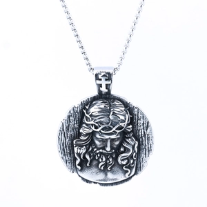 Vintage stainless steel Saint Benedict medal necklace with Jesus relief on white background