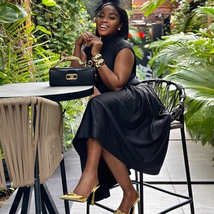 Detail of luxury black leather handbag with iconic gold cheetah handle and metal texture