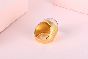 Detailed macro of a gold stainless steel ring featuring a large pink glass stone inlay