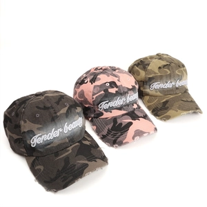Close-up of distressed camouflage baseball caps with 3D embroidery and frayed edge detail