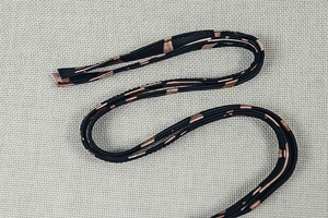 Nahaufnahme der eleganten Leopard-Träger mit filigranen geometrischen Roségold-Mustern