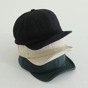 Detailed stitching on three quick-dry short brim baseball caps in black, beige and green