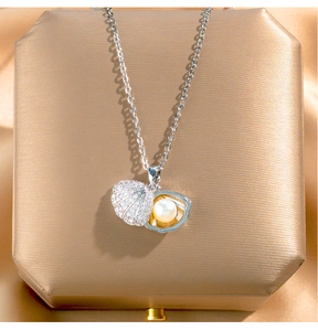 Detailed macro view of an open seashell pendant necklace with pearl and pavé crystals