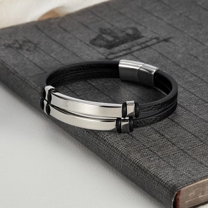 Detail of minimalist black braided leather bracelet with silver magnetic steel clasp