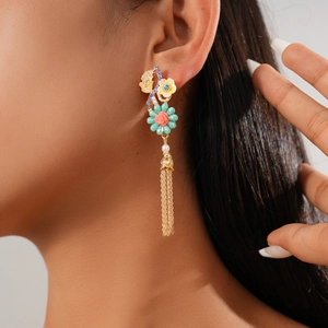 Gros plan détaillé d'une boucle d'oreille fleurie avec pétales colorés et perles sur modèle