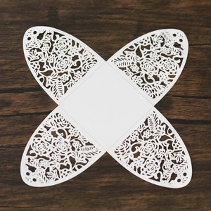 Flat lay macro of intricate white laser-cut floral pattern for wedding candy box
