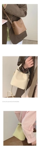 Close-up of minimalist bucket bag with textured leather, top handle and fine hardware details