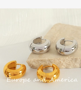 Detailed view of thick chunky hoop earrings in polished gold and silver finishes