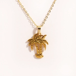 Detailed close-up of golden coconut tree pendant necklace with tropical palm tree design