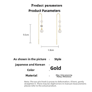 Detail view of gold tassel earrings with three pearls measuring 9.5cm in length