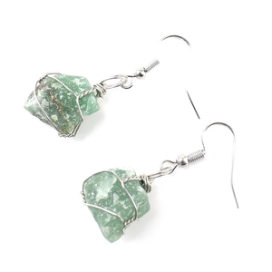 Macro detail of handmade wire-wrapped green natural stone earrings with silver hooks