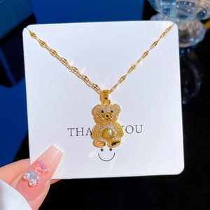 Collier luxueux en acier titane doré avec un pendentif ours serti de cristaux brillants