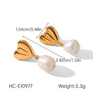 Détail de boucles d'oreilles cœur en métal doré et pendentifs perles baroques