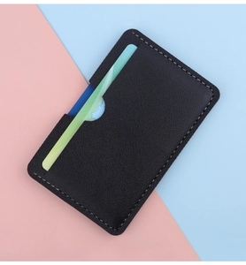Macro shot of black pebbled leather slim card holder with white stitching detail