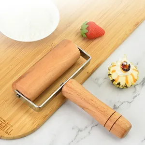 Beechwood T-shape rolling pin with stainless steel frame on a wooden board
