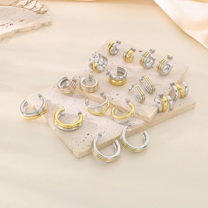 Détail de boucles d'oreilles créoles en acier inoxydable bicolore or et argent