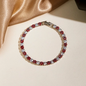 Macro shot of evil eye tennis bracelet with red enamel beads and sparkling zircons