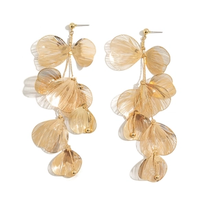 Detailed macro of golden ginkgo leaf dangle earrings with layered textured metal fans