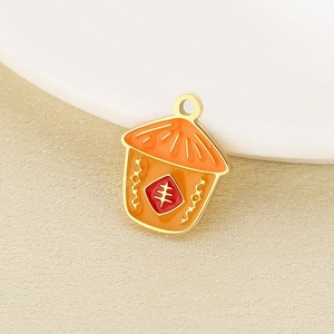Detailansicht eines orangefarbenen Emaille-Anhängers mit goldener Feng-Zeichen-Gravur