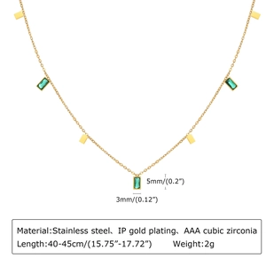 Macro detail of gold plated stainless steel necklace with green cubic zirconia pendant